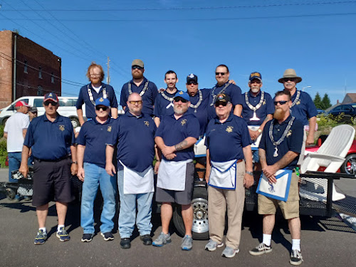 Freemasons in blue shirts gathered in front of a trailer.