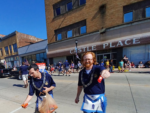 Freemasons handing candy to children during a parade.