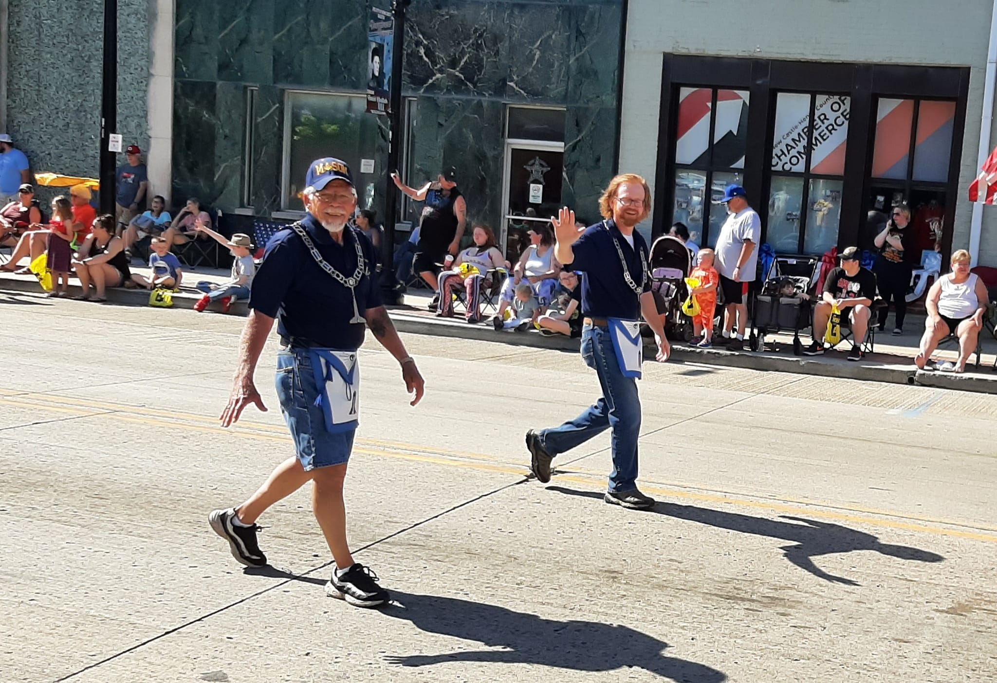 Freemasons walking in a parade and waving.